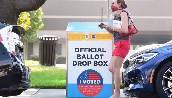 Una mujer que sostiene su boleta pasa junto a un buzón de votación por correo para las elecciones en Estados Unidos de 2020 en Monterey Park, California. (Foto: AFP)