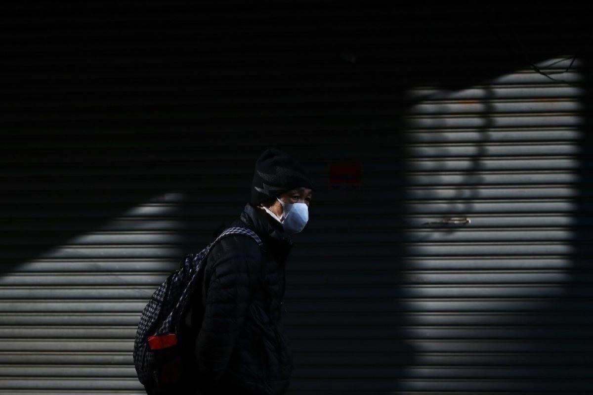 Un hombre camina por una calle en el área de Tsukiji en Tokio. Japón dijo el 17 de febrero que cancelaría una reunión pública para celebrar el cumpleaños del nuevo Emperador Naruhito el 23 de febrero, a medida que crecen los temores sobre la propagación del nuevo coronavirus.  (AFP)