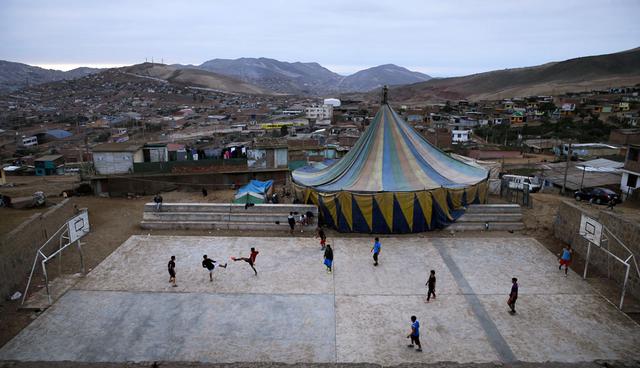 FOTO 1 | Los jóvenes juegan fútbol junto a la carpa de circo Tony Perejil instalada en Puente Piedra. La expansión urbana en la ciudad de 10 millones de habitantes hace que sea difícil encontrar suficiente espacio para instalar una carpa en un vecind
