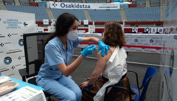 Una sanitaria inocula a una mujer con una vacuna contra el Covid-19 en la antigua plaza de toros Donostia Arena de San Sebastián el 31 de mayo de 2021. (Foto de ANDER GILLENEA / AFP)