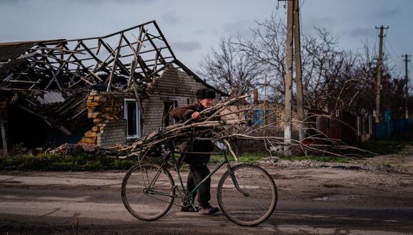 Volodymyr Kovalov, de 77 años, lleva ramas de árboles atadas a su bicicleta mientras recolecta leña para calentar y cocinar en el pueblo de Posad-Pokrovs'ke, región de Kherson, el 26 de diciembre de 2022, en medio de la invasión rusa de Ucrania. (Foto de Dimitar DILKOFF / AFP)