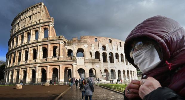 Un hombre con una mascarilla pasa por el Coliseo de Roma. (Foto: Alberto PIZZOLI / AFP).