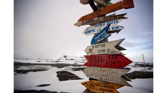 Letreros de madera en forma de flechas muestran las distancias a lugares cercanos a la estación Escudero de Chile en la Isla Rey Jorge, Antártida. Miles de científicos llegan a la Antártida, aunque también lo hacen cocineros, buzos, mecánicos, trabajadore