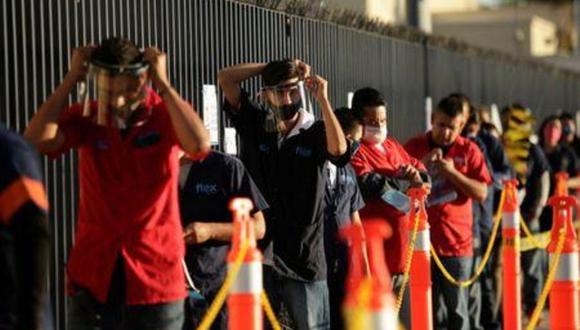 Empleados de Flex, una compañía que elabora productos especializados para la industria automotriz, ajustan sus máscaras protectoras mientras esperan para entrar a la planta durante el primer día de la reapertura gradual de industrias "esenciales" para la economía, en medio de la pandemia de COVID-19, la enfermedad causada por el coronavirus, en Ciudad Juárez, México. 1 de junio, 2020. REUTERS/Jose Luis Gonzalez