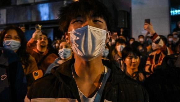 La gente se reúne en una calle de Shanghái el 27 de noviembre de 2022, donde se llevaron a cabo protestas contra la política de cero covid de China la noche anterior luego de un incendio mortal en Urumqi, la capital de la región de Xinjiang. (Foto por Héctor RETAMAL / AFP)
