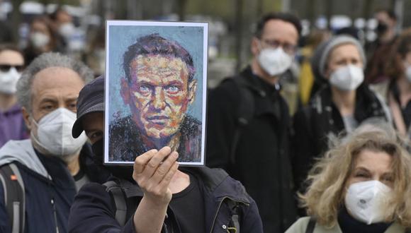 Un manifestante muestra un retrato del crítico del Kremlin Alexei Navalny durante una protesta en su apoyo frente a la cancillería en Berlín, Alemania, el 21 de abril de 2021. (John MACDOUGALL / AFP).