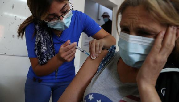 Un trabajador de la salud administra una dosis de la vacuna contra la enfermedad del coronavirus CoronaVac de Sinovac a una mujer sin hogar en Santiago, Chile, el 24 de marzo de 2021. (REUTERS/Ivan Alvarado).