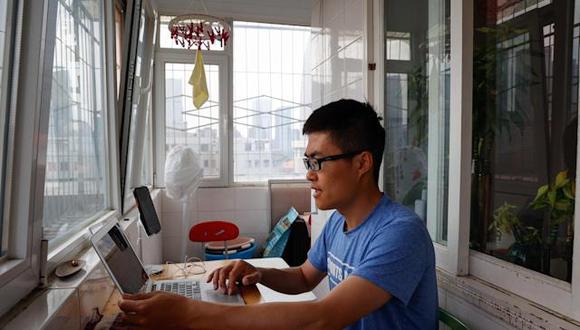 Dragon, un profesor de informatica, trabaja desde casa en Pekín. EFE/EPA/MARK R. CRISTINO