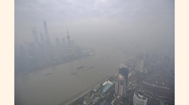 Vista del río Huangpu en la zona financiera del nuevo distrito de Pudong cubierto por una densa niebla. (Foto: REUTERS)