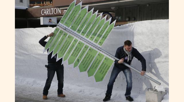 Trabajadores instalan un poste con señales para llegar al Palacio de Congresos de Davos. Los asuntos geopolíticos son considerados la mayor amenaza a la estabilidad global en la próxima década, según expertos sondeados por el Foro Económico Mundial.  (Fot