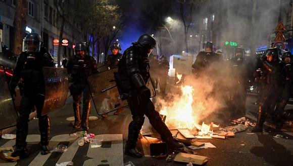 Un gendarme francés incendia una calle durante una manifestación en París, el 18 de marzo de 2023, contra el gobierno francés dos días después de que el gobierno francés impusiera una reforma de las pensiones sin votación utilizando el artículo 49,3 de la constitución. (Foto por JULIEN DE ROSA / AFP)