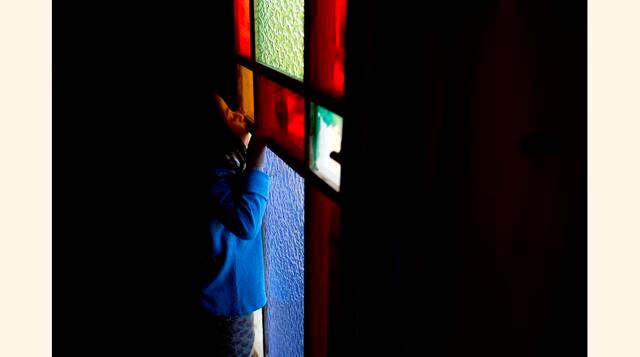 Una niña mira a través de una ventana de cristal de colores en el dormitorio principal de la casa de Pablo Neruda en Isla Negra (Chile). Los vitrales fueron elegidos por Neruda para que pudiera ver el mar de diferentes colores.  (Foto: AP)