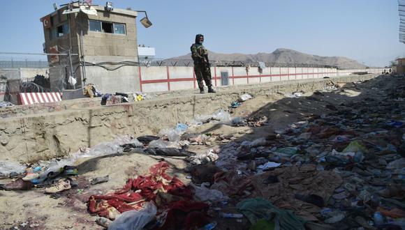 Un combatiente talibán monta guardia en el lugar de las bombas suicidas gemelas del 26 de agosto, que mataron a decenas de personas, entre ellas 13 soldados estadounidenses, en el aeropuerto de Kabul el 27 de agosto de 2021 (Foto de WAKIL KOHSAR / AFP).