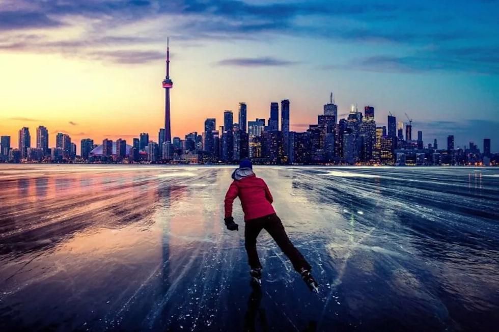 Un hombre patina sobre el hielo en el atardecer con el skyline de Toronto al fondo. (Foto: reddit / Nite1982).