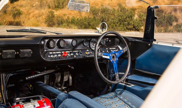 El motor, con sus ocho cilindros y cuatro carburadores, se encuentra justo detrás del conductor. La carrocería es de fibra de vidrio. El velocímetro está frente al asiento del pasajero, el asiento del conductor está atornillado al suelo y los pedales no s