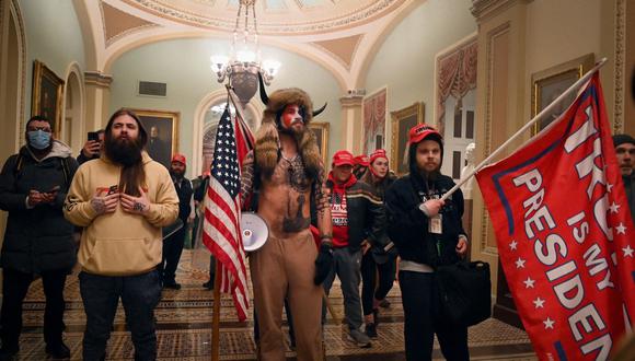 Los partidarios del presidente de los Estados Unidos, Donald Trump, incluido el miembro del grupo de conspiración QAnon, Jake Angeli, también conocido como Yellowstone Wolf (C), ingresan al Capitolio de los Estados Unidos el 6 de enero de 2021 en Washington, DC. (Foto de Saúl LOEB / AFP)