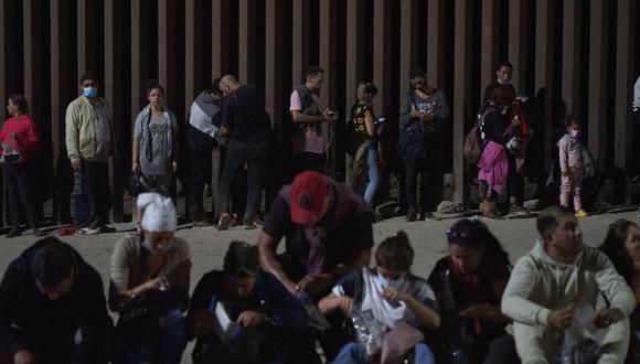 Migrantes esperan ser procesados por la Patrulla Fronteriza de EE. UU. después de cruzar ilegalmente la frontera entre EE. UU. y México en Yuma, Arizona, en la madrugada del 11 de julio de 2022. (Foto de allison cena / AFP)