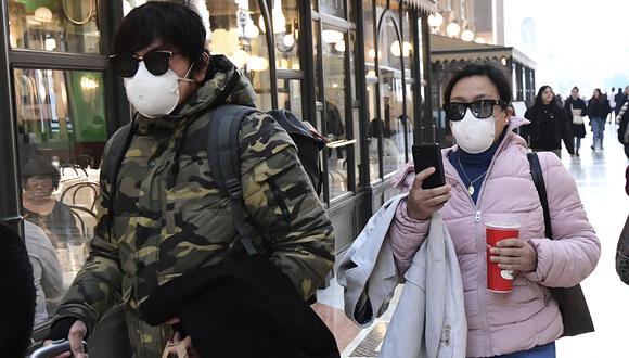Los turistas con una máscara protectora caminan dentro de la Galería Vittorio Emanuele II, cerca de la Piazza del Duomo en el centro de Milán. (Foto: AFP)