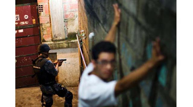 Caracas, Venezuela. Homicidios: 3797. Población: 3.273.863. Tasa de homicidios: 115.98. En la imagen: Oficiales de policía patrullan y buscan sospechosos en la villa Petare en Caracas.