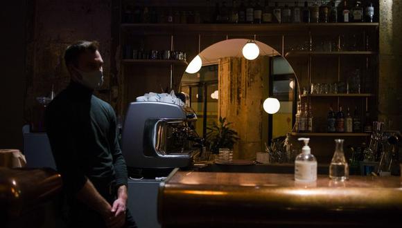 Una botella de desinfectante para manos y un camarero en un bar vacío de un restaurante en París el 28 de septiembre.