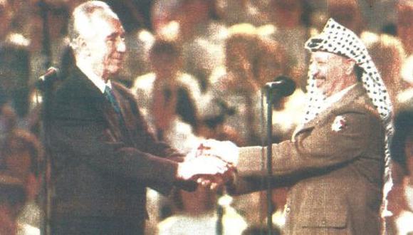 El canciller israelí Shimon Peres y el líder de la OLP, Yaser Arafat, celebran el primer aniversario del acuerdo de paz (foto AFP)