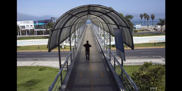 FOTO 4 | En esta imagen, tomada el 24 de marzo de 2020, César Daniel Fiestas cruza un popular paso peatonal vacío tras nadar en las aguas de la playa de Agua Dulce, en Lima, Perú. Este año, los últimos días del verano austral terminaron de forma abrupta cuando el presidente del país declaró el estado de emergencia y el confinamiento de la población para reducir la propagación del nuevo coronavirus. (AP Foto/Rodrigo Abd)