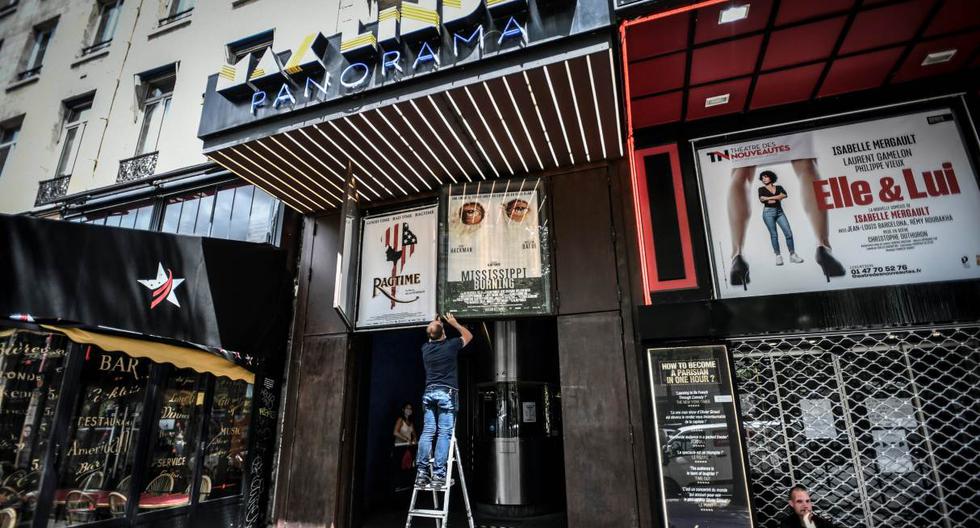 Imagen referencial. Un empleado retira carteles de películas fuera del Teatro Cine Max Linder en París. (STEPHANE DE SAKUTIN / AFP).
