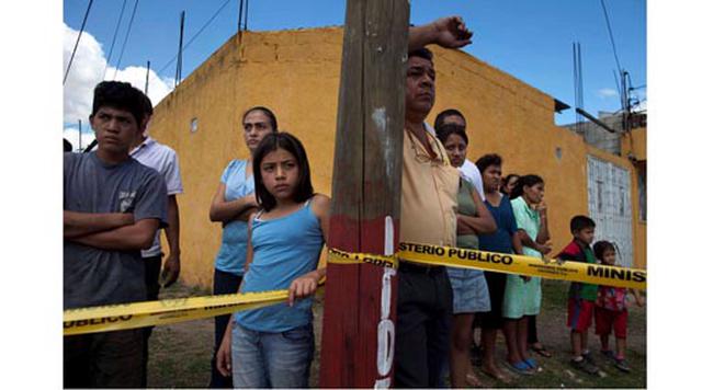 Guatemala, Guatemala. Homicidios: 1.288. Población: 3.074.054. Tasa de homicidios: 41.90. En la imagen: transeúntes observan desde atrás de la cinta policial una escena del crimen en la Ciudad de Guatemala.
