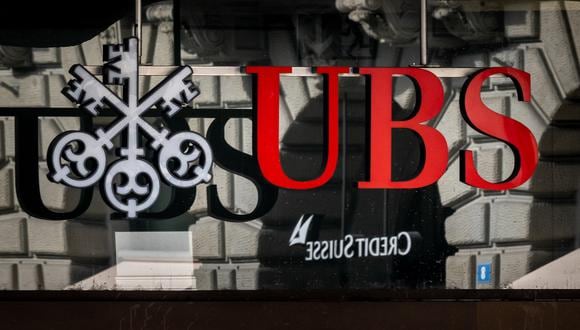 Una fotografía muestra un logotipo del banco gigante suizo UBS frente a un logotipo del banco Credit Suisse en Zúrich el 19 de marzo de 2023. (Foto de Fabrice COFFRINI / AFP)
