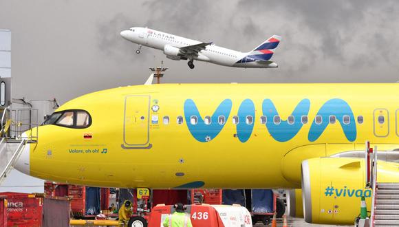 Se ve un avión de Latam despegando sobre un avión de Viva Air en el Aeropuerto Internacional El Dorado de Bogotá, el 14 de mayo de 2022. (Foto de DANIEL MUNOZ / AFP)