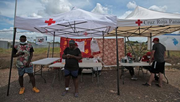 Migrantes permanecen bajo carpas de la Cruz Roja en la Estación de Recepción de Migrantes (ESM) de San Vicente en Meteti, provincia de Darién, Panamá, cerca de la frontera con Colombia. (Foto de ROGELIO FIGUEROA / AFP).