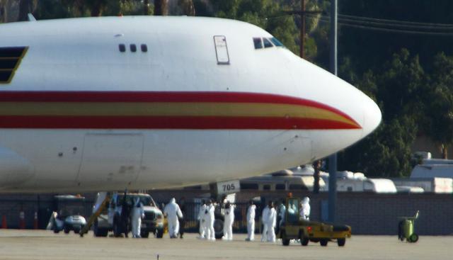 El personal con trajes de riesgo biológico aguarda a los pasajeros estadounidenses evacuados de Wuhan. Avión aterrizó en Riverside, California. (AFP).