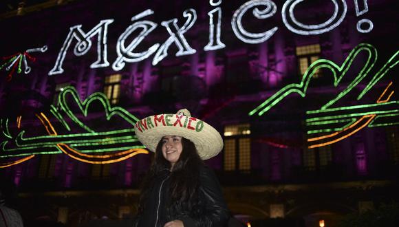 Una mujer posa frente al iluminado edificio del Municipio de México en vísperas de la celebración del Día de la Independencia de México en la Plaza del Zócalo de la Ciudad de México el 14 de septiembre de 2017 (Foto: Yuri Cortez / AFP )