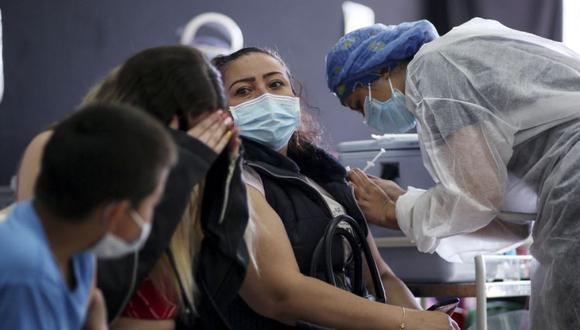Un trabajador de la salud inocula a una mujer la vacuna CoronaVac, desarrollada por la china Sinovac contra la enfermedad del nuevo coronavirus COVID-19, en un centro de vacunación en Bogotá. (Foto: Leonardo MUÑOZ / AFP).