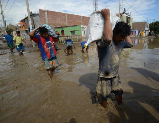 Son los propios vecinos que, pala en mano, retiran el barro (donde se puede, claro) para limpiar sus calles. Es la propia población la que, con su dinero, contrata maquinaria pesada para la remoción de escombros. (Foto: AFP)