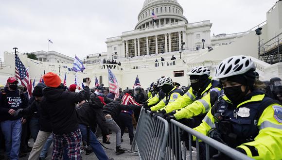 Los partidarios de Trump tiraron barricadas y se enfrentaron con la policía en los terrenos del Capitolio, y entraron al edificio. (AP Photo/John Minchillo)