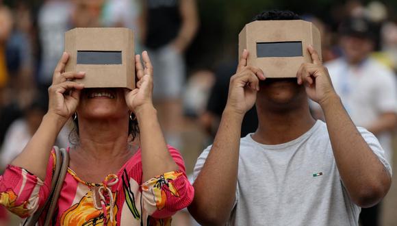 Mientras algunos podrán observar el eclipse solar, otros no podrán hacerlo por el mal clima. Aquí l gente disfrutando del fenómeno en Manaos, estado de Amazonas, Brasil, el 14 de octubre de 2023 (Foto: Michael Dantas / AFP)