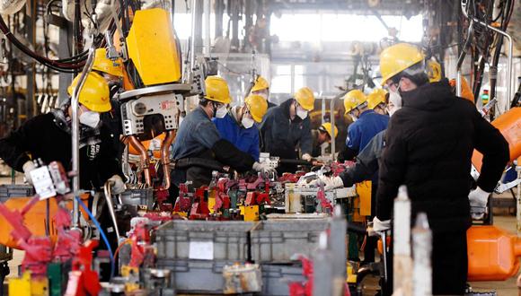 Los empleados trabajan en una línea de montaje de una fábrica de Wuling Motors en Qingdao, en la provincia oriental china de Shandong, el 1 de marzo de 2023. (Foto de AFP)