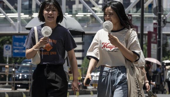 Japoneses usan miniventiladores para refrescarse ante la ola de calor por el calentamiento global. (Foto: AFP)