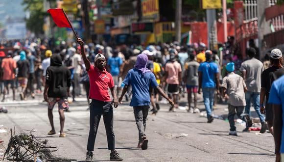 Decenas de personas protestan, en Puerto Príncipe (Haití). La violencia, los saqueos y las manifestaciones para forzar la dimisión del primer ministro de Haití, Ariel Henry, marcaron este jueves la vida en un país en el que, ante el agravamiento de la situación, varias embajadas cerraron su puertas. (Foto: EFE/ Johnson Sabin)
