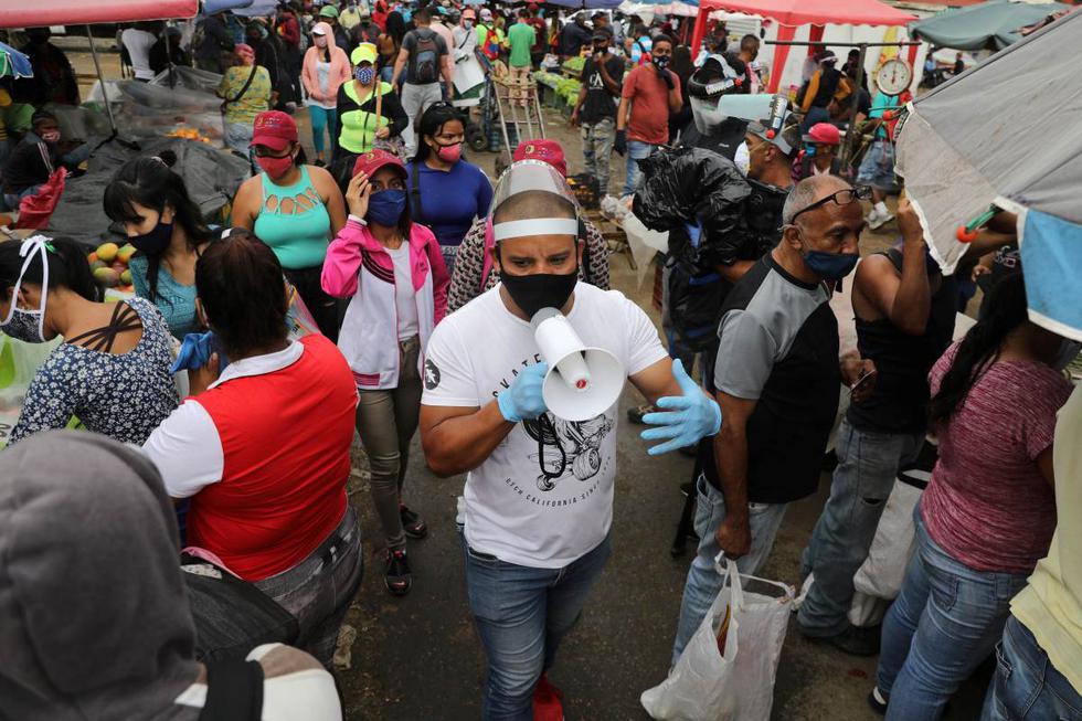 Walter Rivera, director del mercado mayorista de Coche, grita las reglas para prevenir el coronavirus en Caracas, Venezuela. (REUTERS/Manaure Quintero).