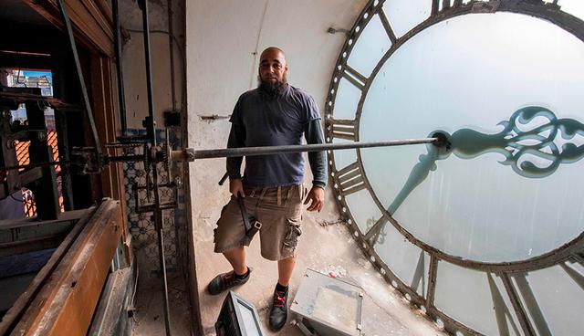FOTO 9 | Uruguay. El relojero uruguayo Abdel Ghaffar (nacido como Raúl Amaral) posa junto al reloj de la Catedral de Montevideo, en Montevideo el 19 de marzo del 2018. (Foto: AFP)