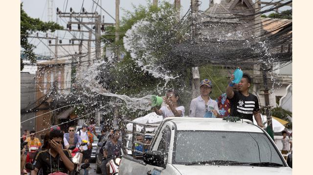 La atención se centra en las ya famosas batallas con mangueras y pistolas de agua que abarrotan las calles del país. (Foto: AP)