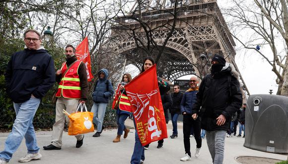 Los manifestantes sostienen banderas de los sindicatos CGT durante una huelga del personal de la Torre Eiffel. (Foto: AFP)