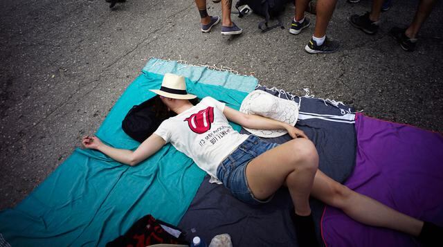 Una fan descansa en el piso mientras espera fuera del lugar de encuentro para el concierto de los Rolling Stones en La Habana. (AP)
