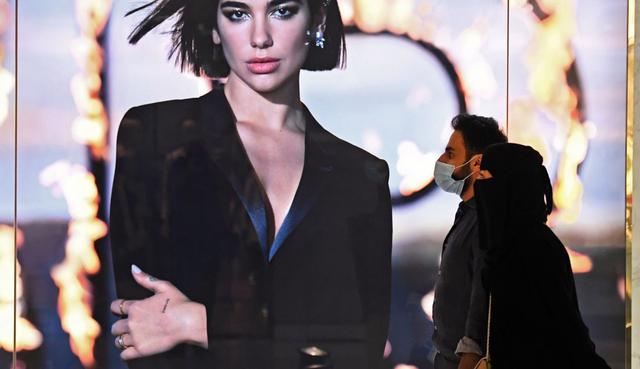 Las personas, que usan máscaras protectoras para combatir la propagación del coronavirus, caminan el 28 de abril de 2020 por el centro comercial de Dubai. (AFP / Karim SAHIB).