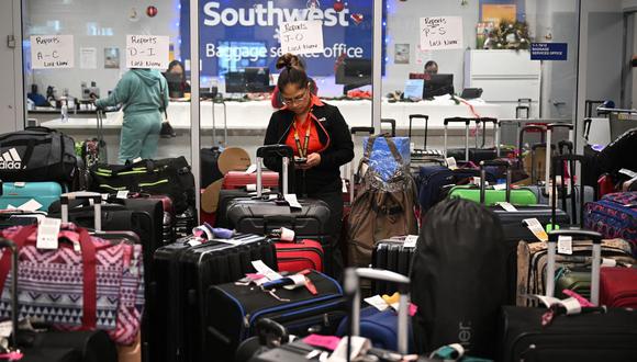 Un miembro de la tripulación de tierra de Southwest Airlines organiza el equipaje no reclamado en el área de equipaje de Southwest Airlines, el 28 de diciembre de 2022 en el Aeropuerto Internacional de Los Ángeles en Los Ángeles. (Foto de Robyn BECK / AFP)