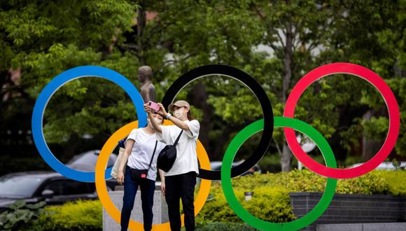 Turistas se toman selfies con los anillos olímpicos en Tokio (Japón)a poco que empiece la competencia. En la justa habrá 31 peruanos compitiendo. (Foto de Behrouz MEHRI / AFP).