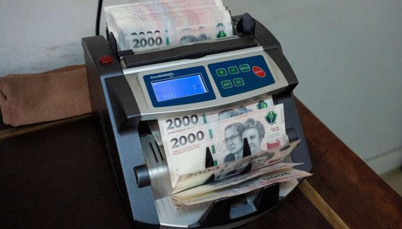 Un trabajador utiliza una máquina para contar billetes de pesos argentinos en una casa de cambio de divisas en Buenos Aires, Argentina, el miércoles 10 de enero de 2024.