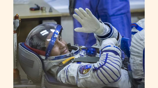 El miembro de la tripulación de la Estación Espacial Internacional, Kjell Lindgren, saluda a los presentes mientras revisan su traje espacial en el cosmódromo de Baikonur, Kazajstán. (Reuters)